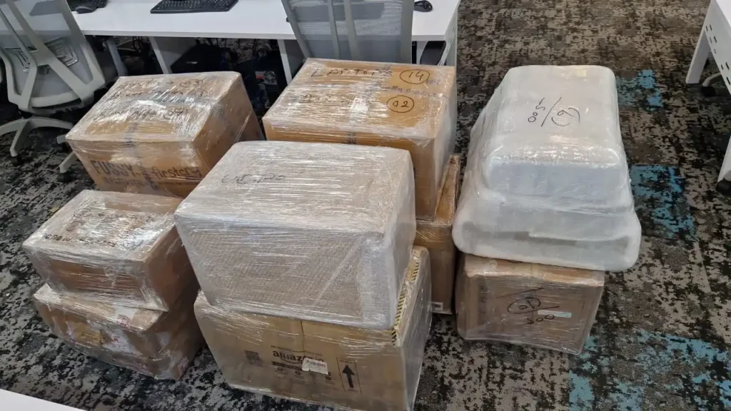 how to pack fragile items for moving - staff wrapping glassware and boxes with bubble wrap and tape
